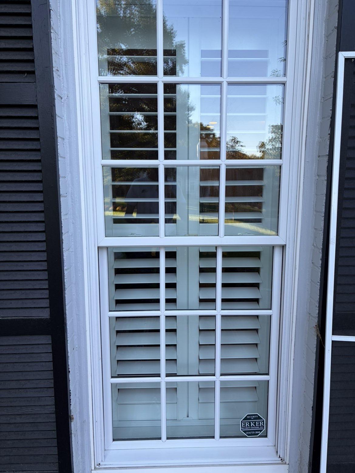 After cleaning: White divided-light window beside dark shutters