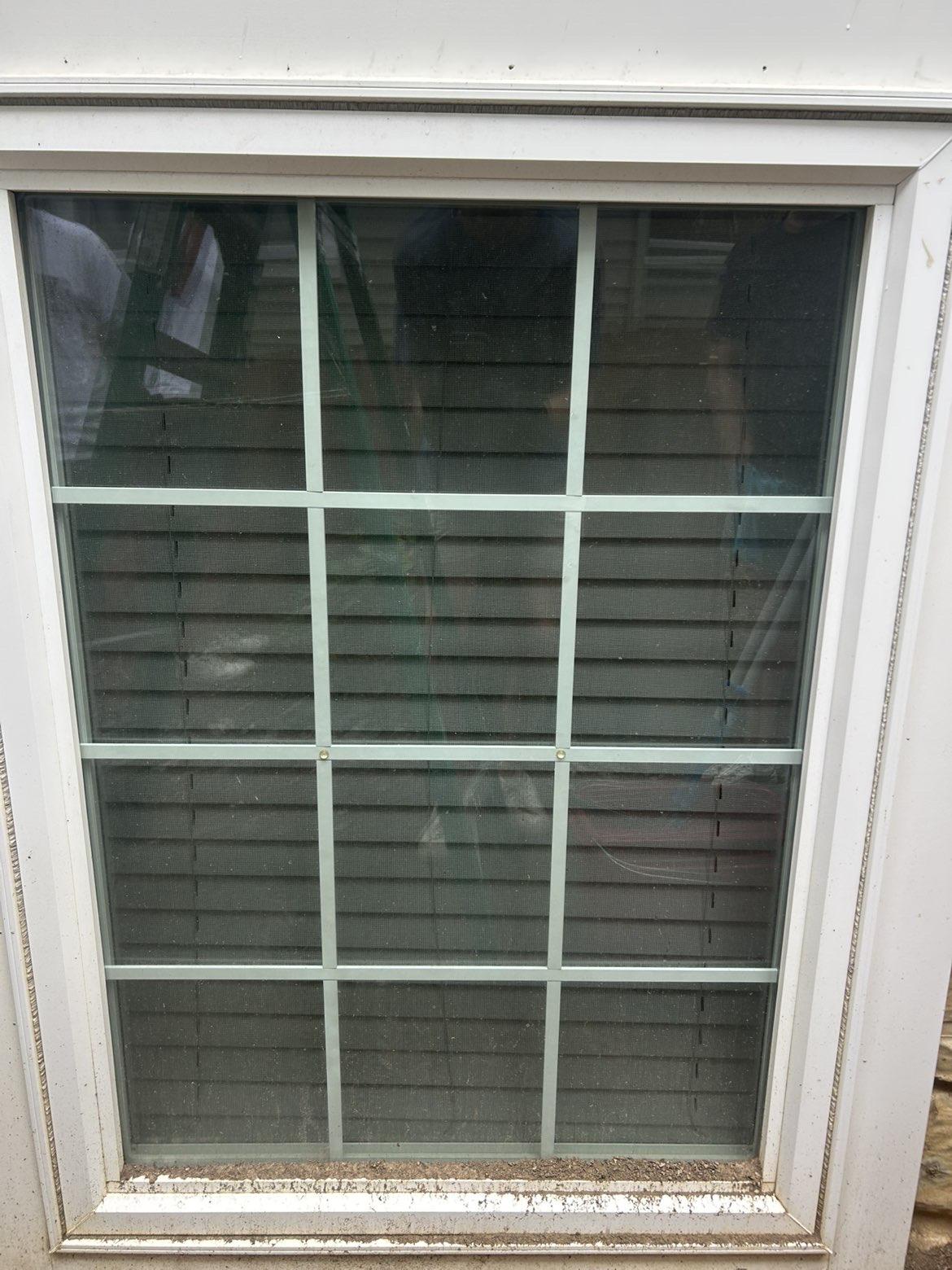 Before cleaning: White framed window with blinds