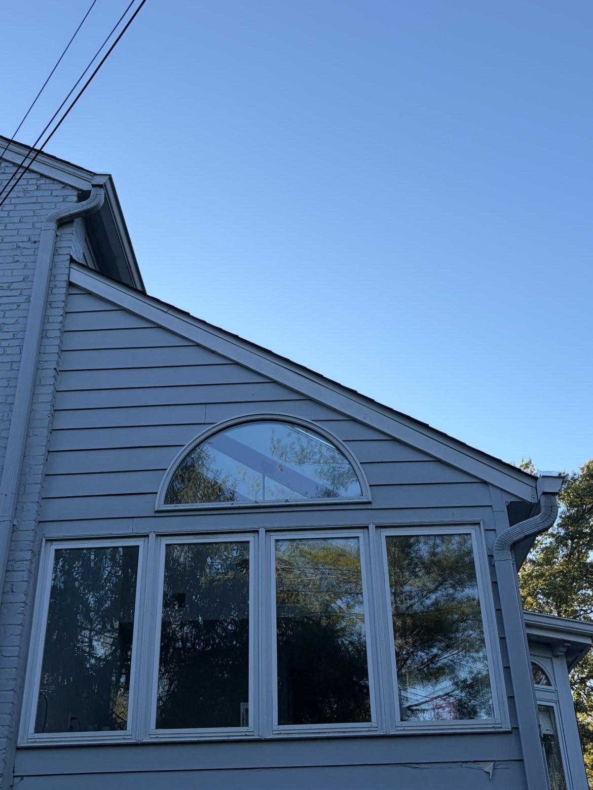Clean windows with an arched transom on a gray house