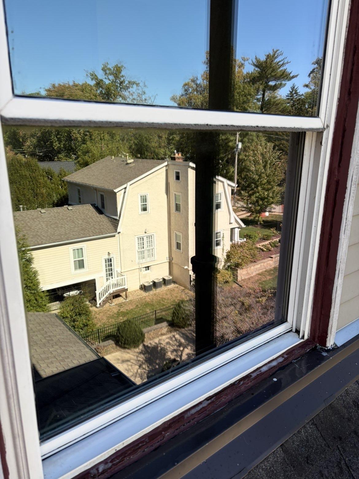 After cleaning: Open window reflecting neighboring homes and trees