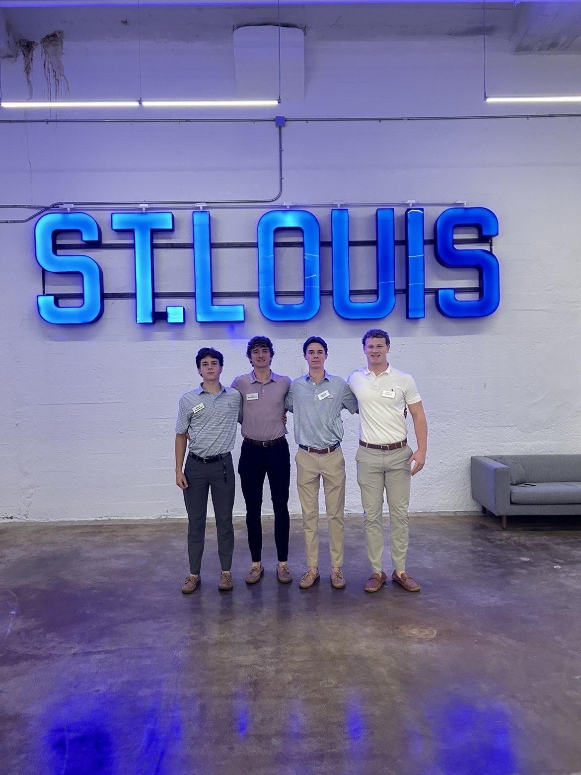 The Window Guys STL team standing in front of a glowing St. Louis sign